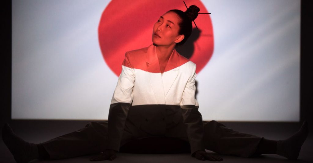 Projection du drapeau du Japon, disque rouge sur fond blanc, derrière une femme assise